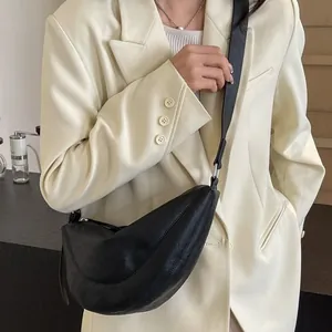Minimalistische zwarte halve maan crossbody tas met verstelbare riem en lederen textuur