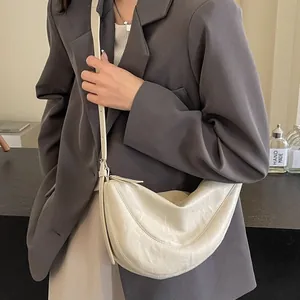 Minimalistische beige maanvormige crossbodytas van zacht leer met verstelbare riem