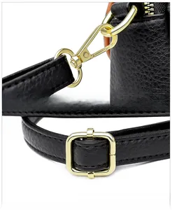 Detail of premium black lychee leather bag with gold metal hooks and adjustable strap