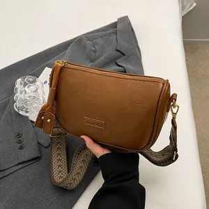 Vintage brown leather crossbody bag with ethnic style wide strap and elegant metal logo