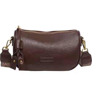 Retro dark brown cylinder crossbody bag with vintage metallic zipper and ethnic woven strap