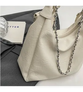Detail of cream pleated PU leather bag with silver chain strap and zipper closure