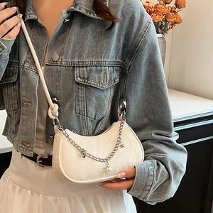 Sac hobo blanc à texture plissée, chaîne argentée et breloques cœur en décor lifestyle
