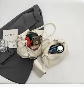 Detailed view of cream PU leather crossbody set with silver chain strap and interior space