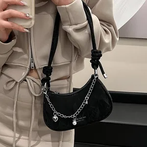 Sac demi-lune noir à texture froncée, chaînes métalliques et breloques perles