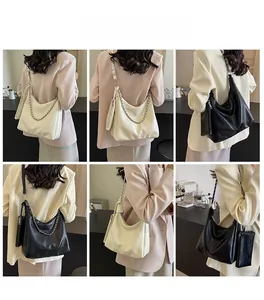 Detail view of stylish white and black hobo bags with metal chains and mini pouches