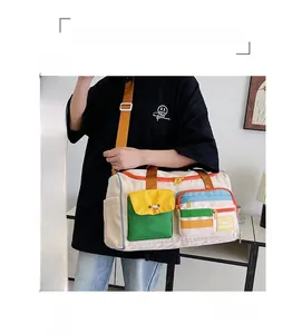 Dettaglio della borsa da viaggio color-block con tasche multiple e tracolla regolabile