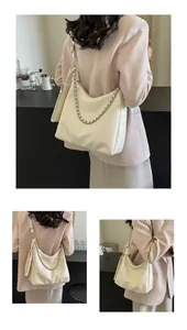 Detail view of cream white hobo bag with gold chain and matching small zip pouch