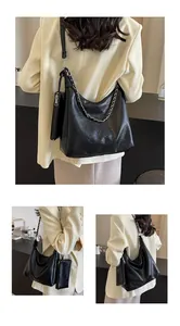 Detail view of black textured leather shoulder bag with silver chain and inner pouch set