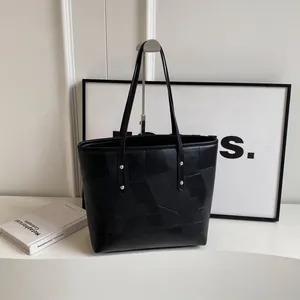 Minimalist black patchwork tote bag with silver rivets and large capacity shoulder straps