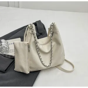 Detail of off-white pleated leather bag set with silver chain strap and mini pouch