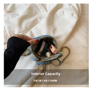 Internal capacity of mini blue denim crossbody bag showing makeup storage details