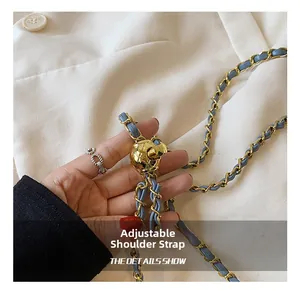 Detail showing the adjustable gold metal ball buckle on a blue leather chain strap