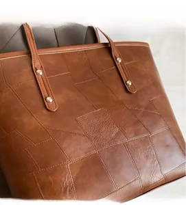 Close-up of brown faux leather tote bag showing unique stitched texture and rivets