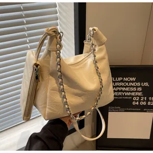 Detail of white pleated leather bag with silver chain strap and mini pouch attachment