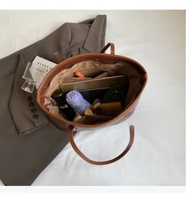 Interior view of brown faux leather tote bag showing large capacity and striped lining