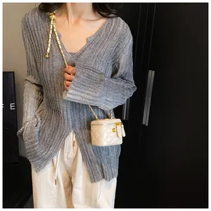 Detailed view of cream quilted mini chain bag worn by a model to show actual size