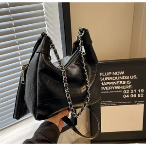 Close-up of black pleated faux leather bag with silver chain and mini coin pouch