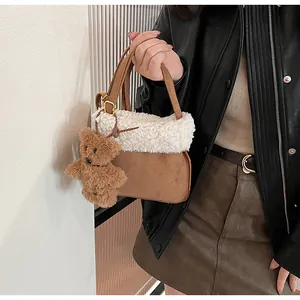 Detail showing plush lamb wool and brown suede texture with a cute bear charm