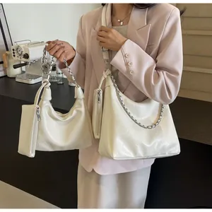 Detail view of cream white pleated hobo bags with silver chain straps and mini pouches