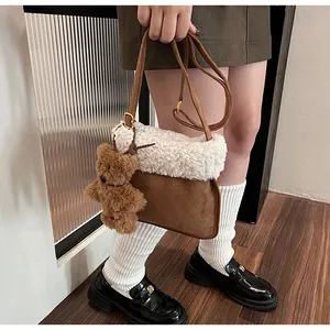 Detail of wool fleece and brown suede crossbody bag with cute plush bear charm