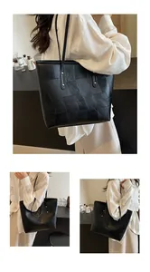 Detail of black tote bag with geometric leather patchwork textures and silver studs