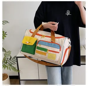 Dettaglio borsa da viaggio color-block con tasche gialle e scritta Hello Weekend
