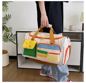 Dettaglio della borsa da viaggio in tela colorata con design Hello Weekend e tasche