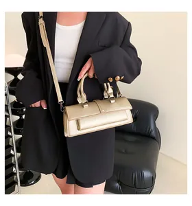 Makroaufnahme einer metallic champagnergoldenen Handtasche mit dunkelgrauen Metallbeschlägen