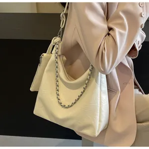 Close-up of off-white pleated hobo bag with silver chain and detachable mini pouch