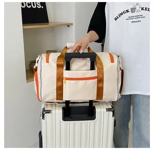 Dettaglio della borsa da viaggio beige con fascia per trolley fissata su una valigia