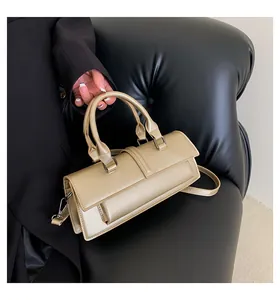 Detail einer beigen rechteckigen Handtasche mit matter Lederstruktur und Silberschnallen
