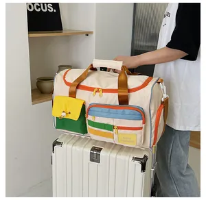 Dettaglio della borsa da viaggio multicolore con etichetta Hello Weekend e fibbie