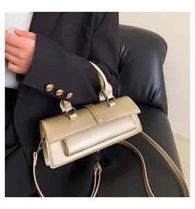 Details einer champagnergoldenen Handtasche mit Struktur und verstellbarem Schultergurt