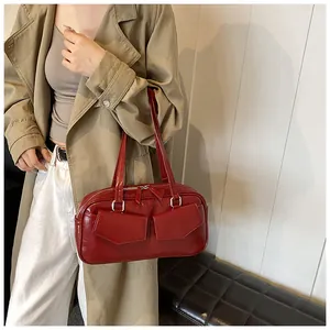 Detalle de bolso de hombro brillante rojo oscuro con dos bolsillos con solapa y pulido