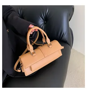 Detailansicht der khakifarbenen Zylindertasche mit glatter Lederstruktur und Metallbeschlägen