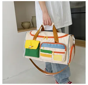Dettaglio borsa da viaggio con tasca anteriore colorata e tracolla regolabile marrone