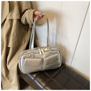 Detalle de bolso de hombro plateado metalizado con bolsillos delanteros dobles