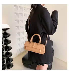 Detailansicht einer stylischen kamelledernen Handtasche getragen von einem Model