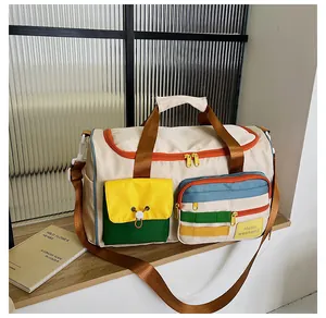 Dettaglio della borsa da viaggio in nylon beige con tasche a contrasto e zip arancione