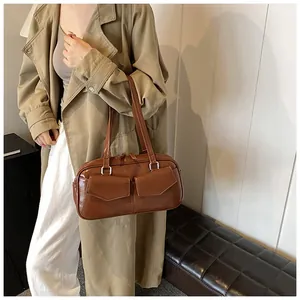 Bolso de hombro marrón de piel sintética con dos bolsillos en modelo con gabardina