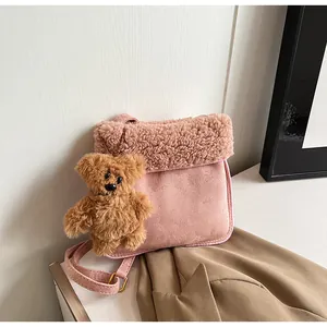 Detailed macro view of pink lamb wool faux suede crossbody bag with cute teddy bear charm