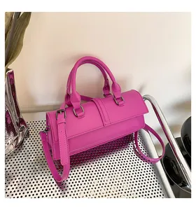 Detailansicht einer magentafarbenen Handtasche mit silbernen Schnallen und Lederstruktur
