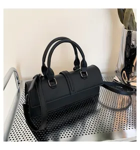Detail der schwarzen Leder-Boston-Bag mit Doppelgriffen und silbernen Beschlägen am Ständer