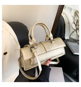 Detailaufnahme der champagnergoldenen Handtasche mit Metallic-Finish und Rundgriffen