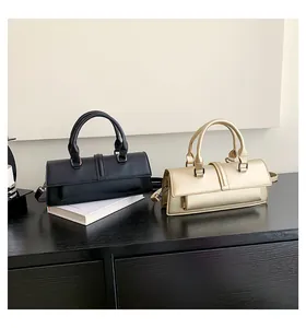 Nahaufnahme von schwarzen und champagnergoldenen Rechteck-Handtaschen mit vertikalen Schnallen