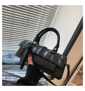 Detailansicht der schwarzen Lederhandtasche mit matter Textur und dekorativer Schnalle