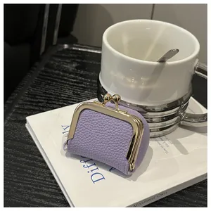 Macro shot of lilac pebble grain leather coin purse with golden kiss-lock closure