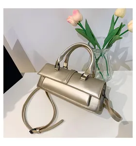 Detail der champagner-goldenen Handtasche mit Metallic-Textur und edlem Metallverschluss