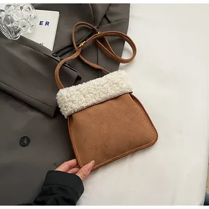 Detail of suede crossbody bag with plush faux shearling trim and brown leather strap